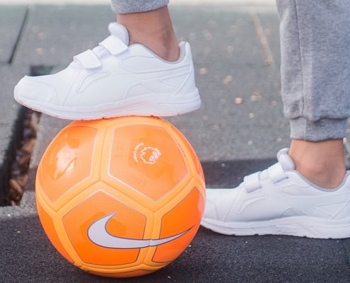 zapatillas blancas y balón de fútbol